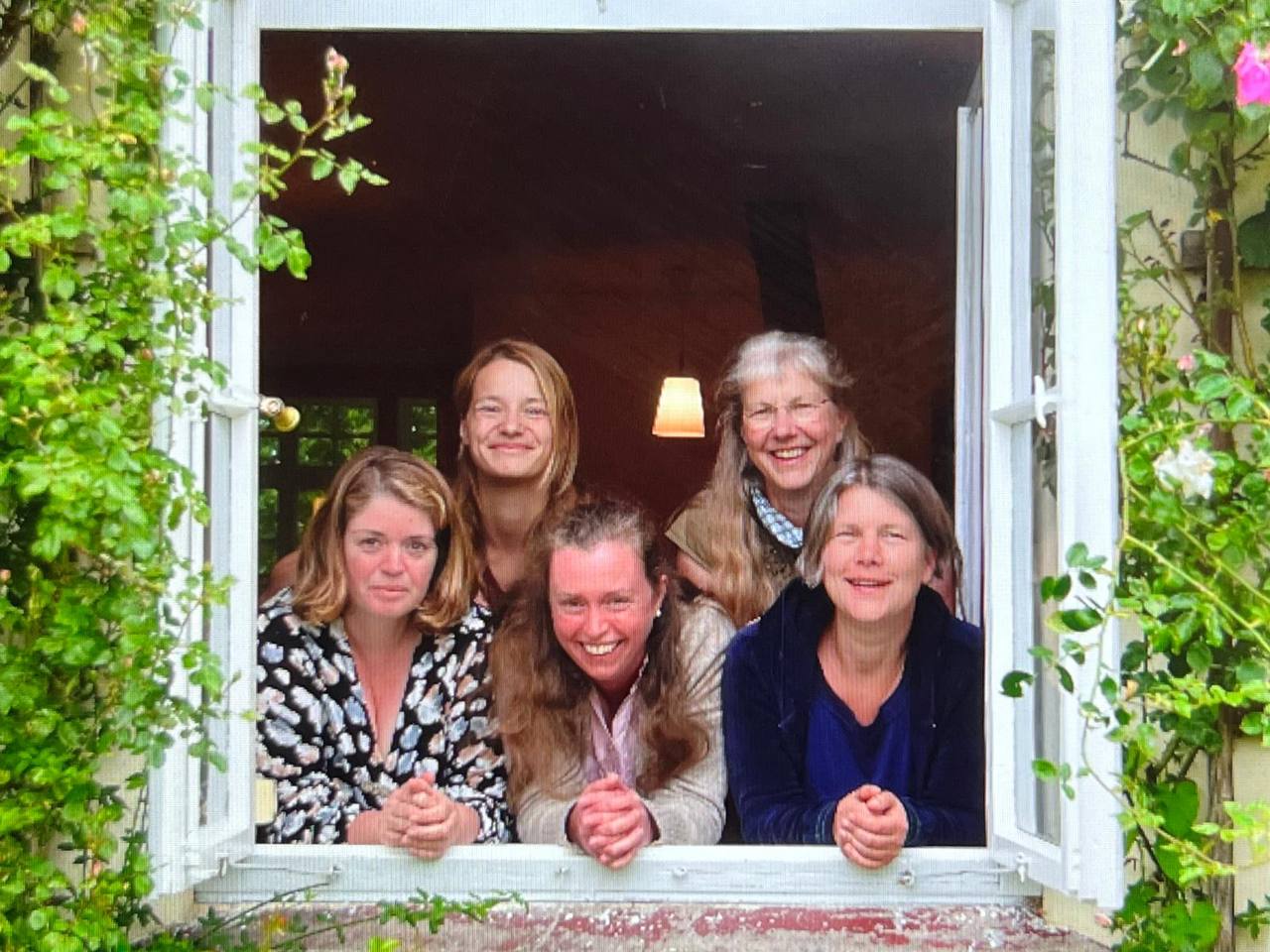 UnserTeams schaut lachend aus dem Fenster